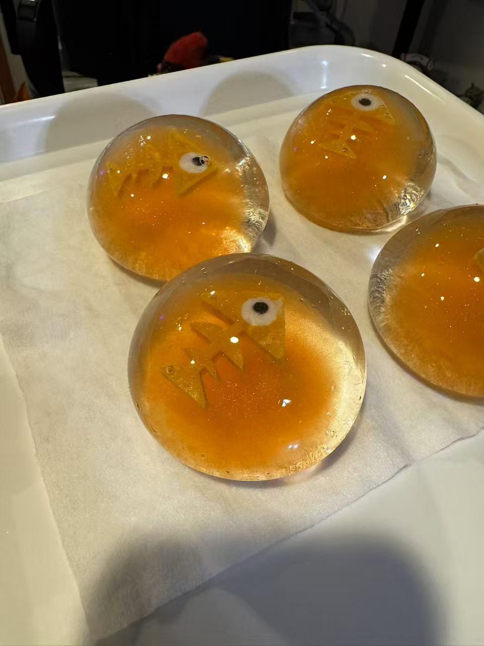 Translucent amber fish-egg silicone squeeze toys on a tray